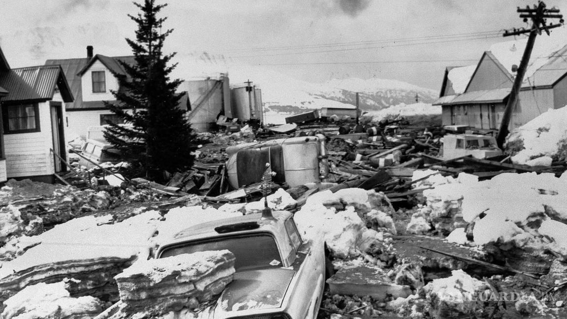 $!Autos enterrados dañados por enormes bloques de hielo empujados a la orilla por el tsunami luego del gran terremoto en Valdez, Alaska, que golpeó con fuerza letal el 29 de marzo de 1964.