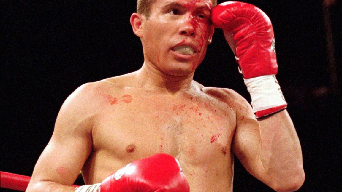 $!Julio César Chávez se cubre el ojo izquierdo durante su pelea con Oscar De La Hoya en Las Vegas, el 7 de junio de 1996. AP/Jeff Scheid