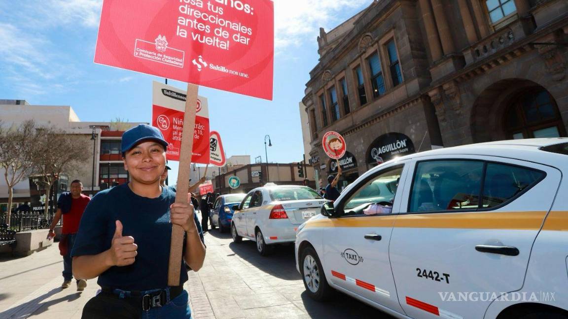$!Ciudadanos observarón carteles informativos sobre las reglas de tránsito mientras transitan por el centro de Saltillo.