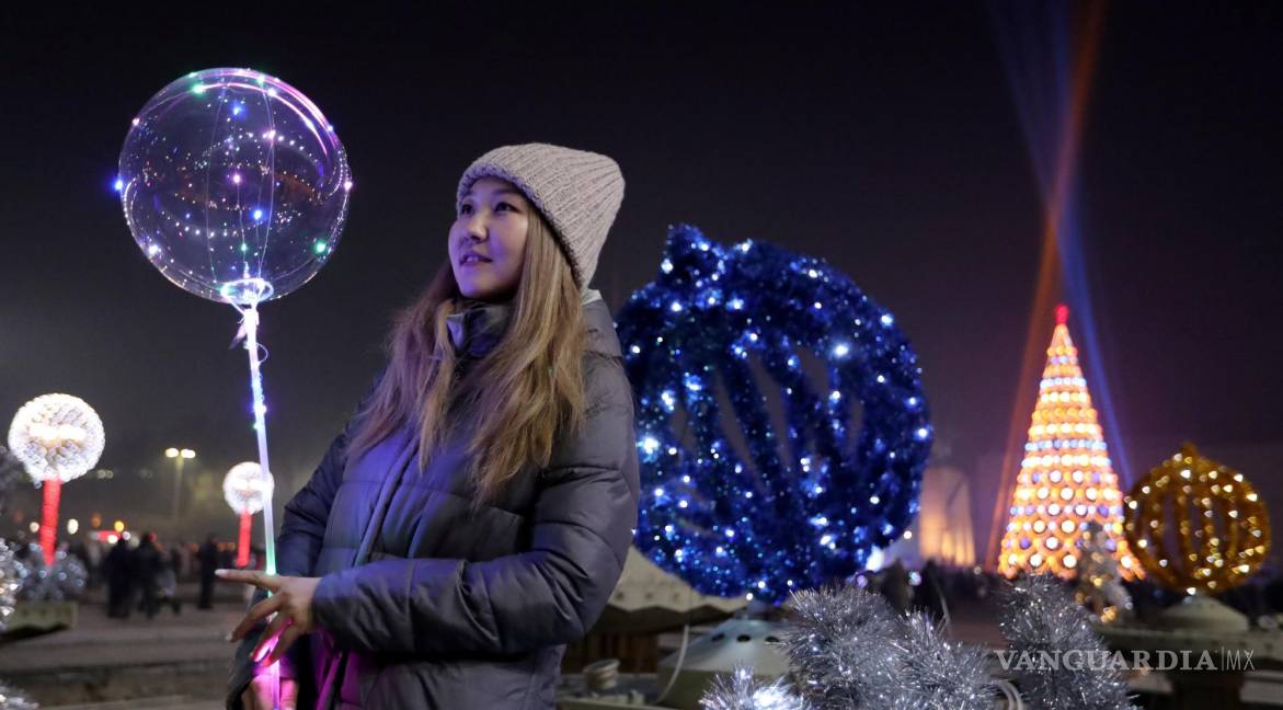 $!Los niños se paran cerca de adornos navideños iluminados en la plaza central Ala-Too en Bishkek, Kirguistán. EFE/EPA/Igor Kovalenko