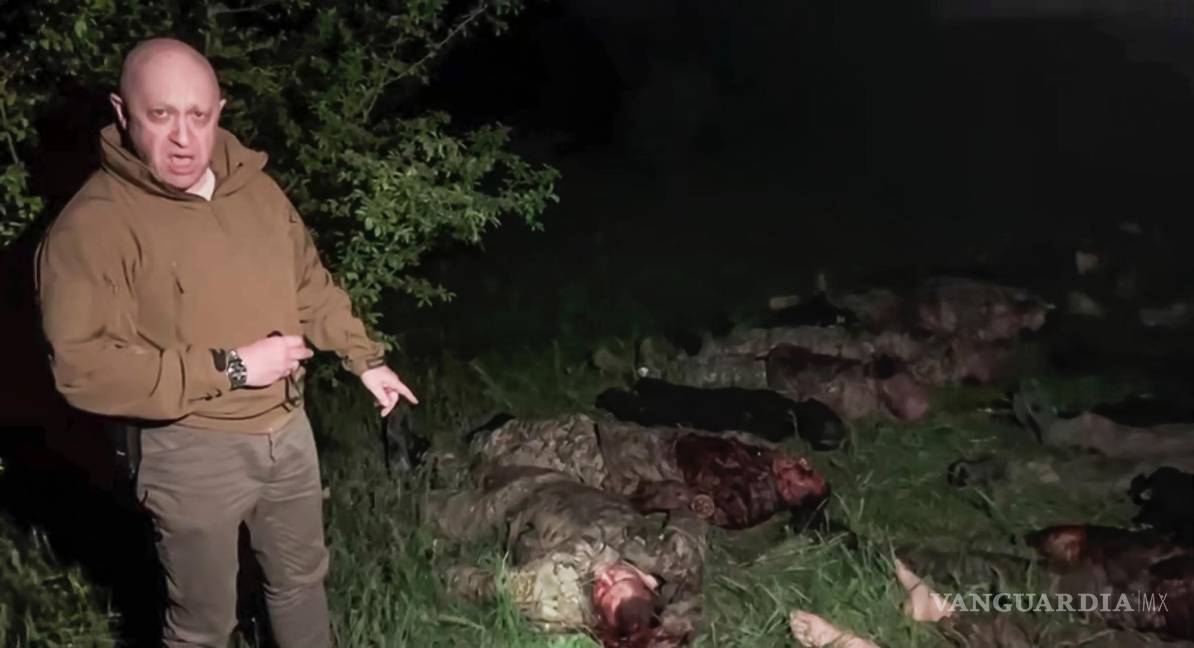 $!El jefe del contratista militar privado ruso Grupo Wagner, Yevgeny Prigozhin, señala varios cadáveres tirados en un lugar desconocido.