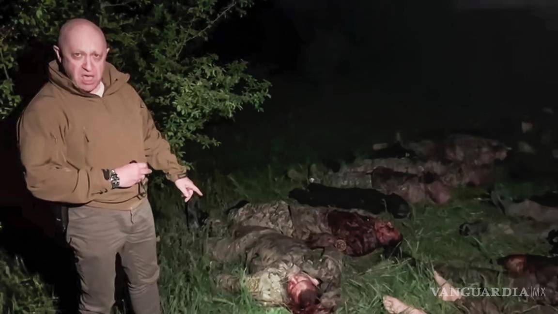 $!El jefe del contratista militar privado ruso Grupo Wagner, Yevgeny Prigozhin, señala varios cadáveres tirados en un lugar desconocido.