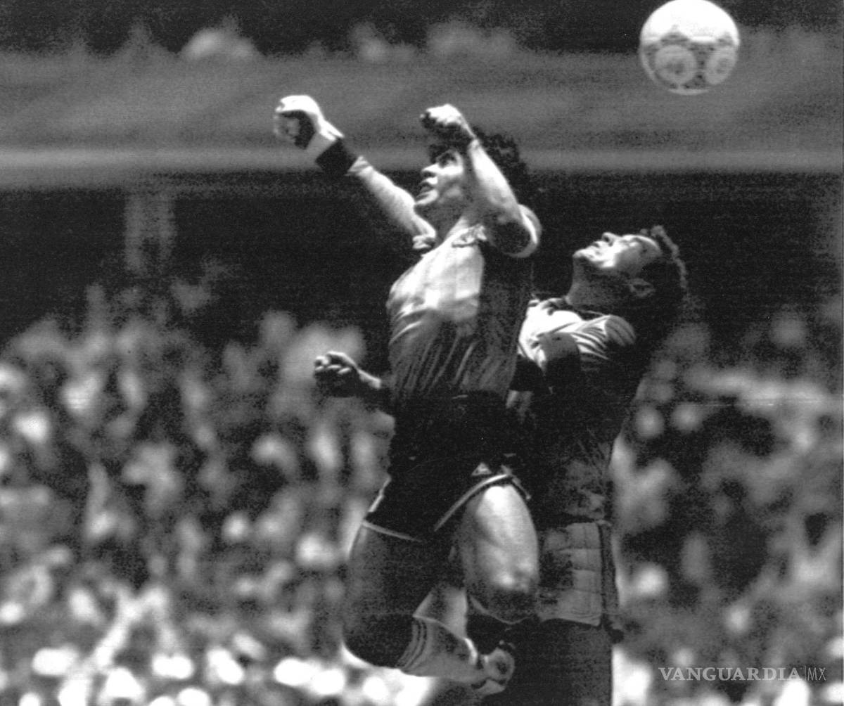 $!Diego Maradona vence al portero inglés Peter Shilton y anota el primero de dos goles en los cuartos de final de la Copa del Mundo, en la Ciudad de México.