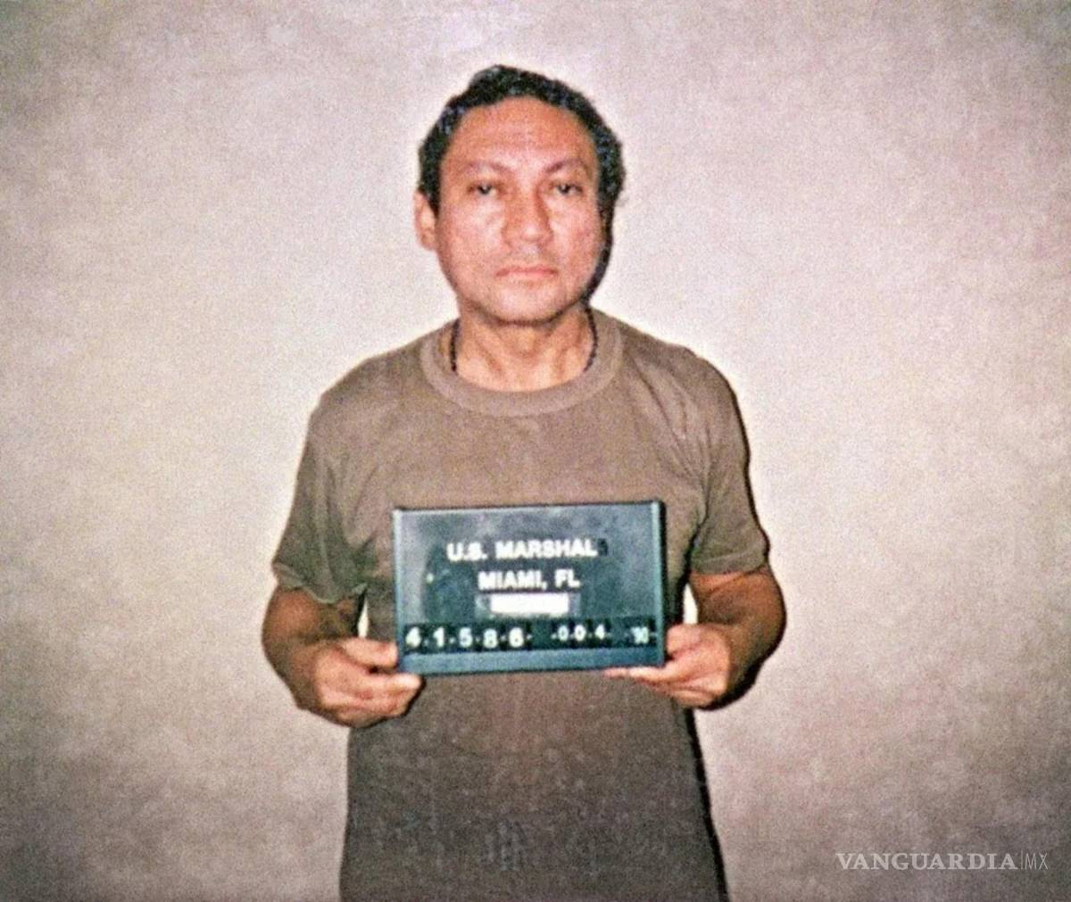 $!Fotografía de archivo de 1990 del fallecido ex general panameño Manuel Antonio Noriega sosteniendo su ficha policial tras ser detenido por EU.