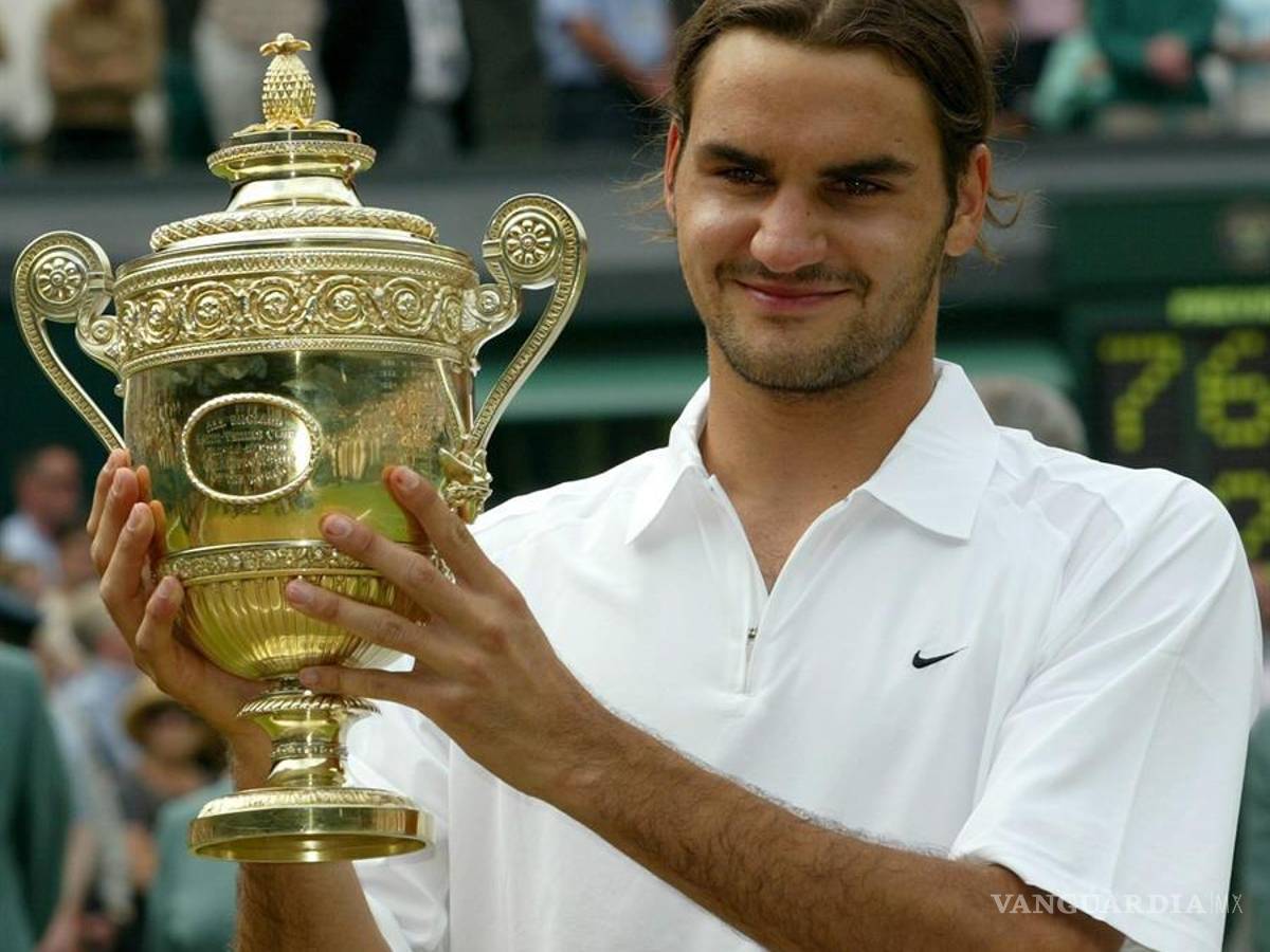 $!Roger Federer sostiene el trofeo tras de ganar la final contra Mark Philippoussis en Wimbledon, el domingo 06 de julio de 2003.