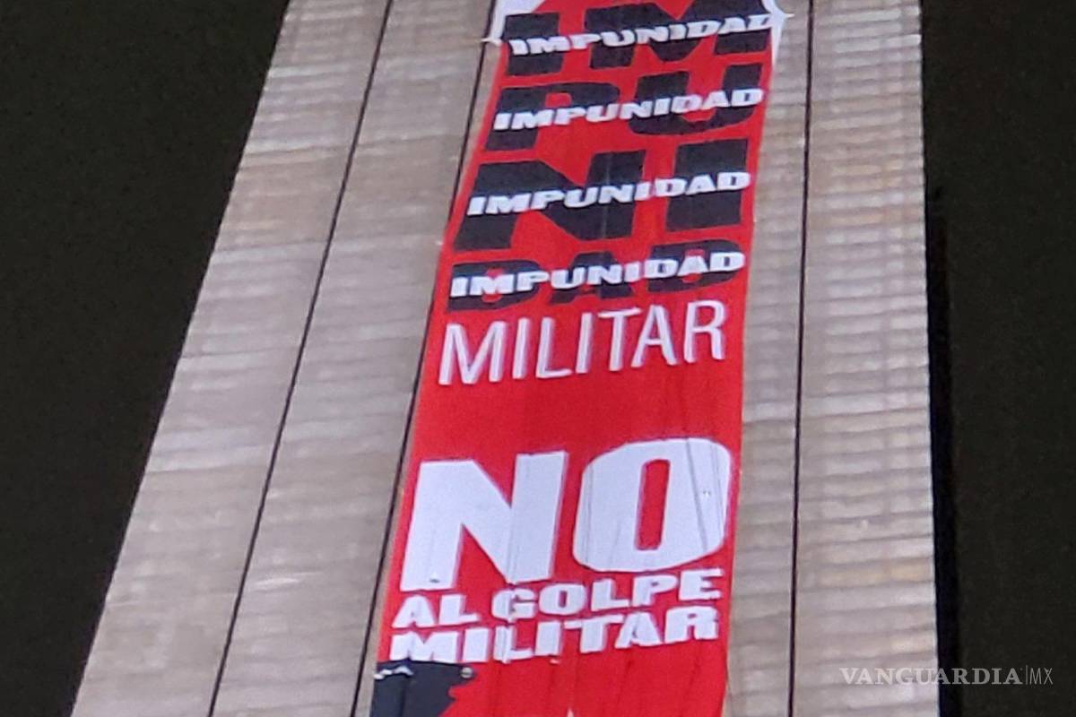 Mujeres activistas escalan y despliegan enorme lona en la ‘Estela de Luz’ durante Grito de AMLO en la CDMX