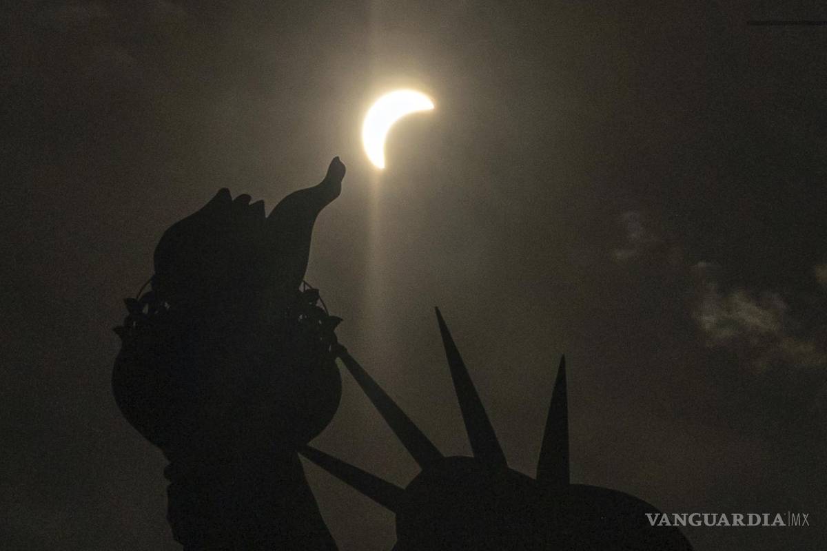 $!The moon partially covers the sun behind the Statue of Liberty during a total solar eclipse on the Liberty Island, Monday, April 8, 2024, in New York. (AP Photo/Yuki Iwamura)