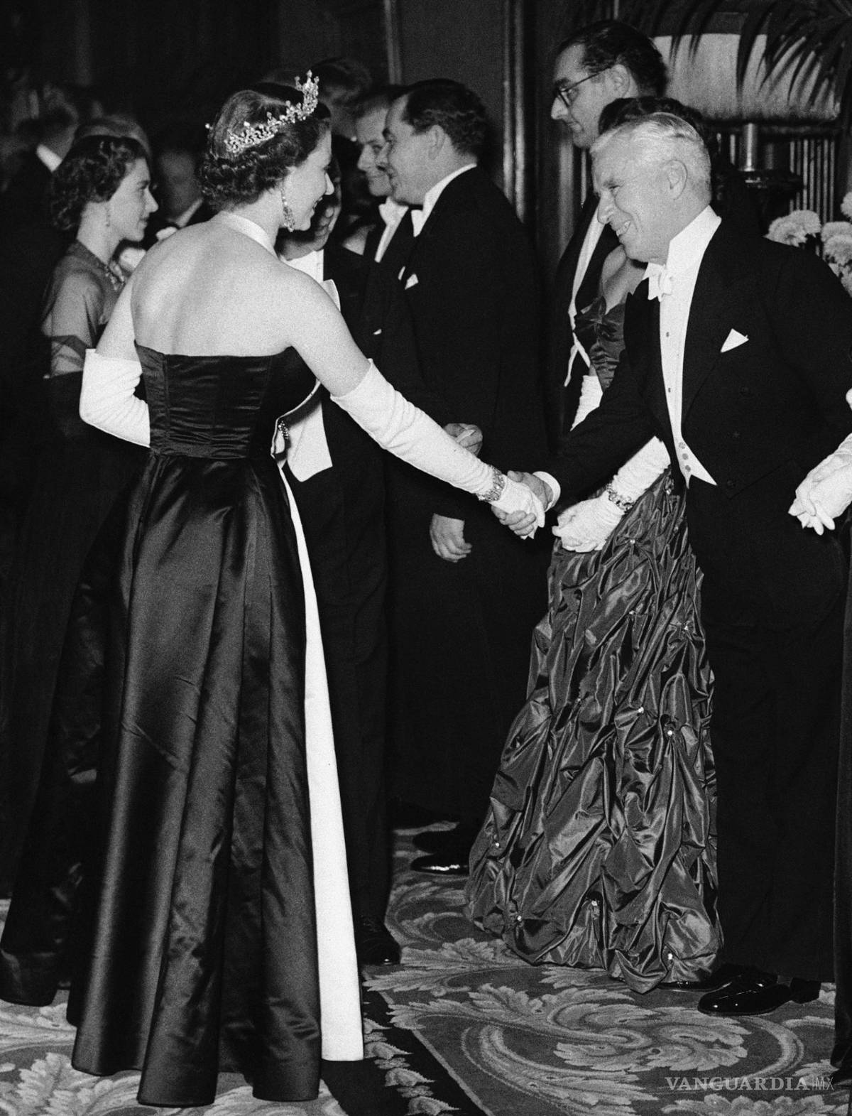 $!La reina Isabel II saluda al actor Charlie Chaplin en el Teatro Imperio en Londres el 27 de octubre de 1952.