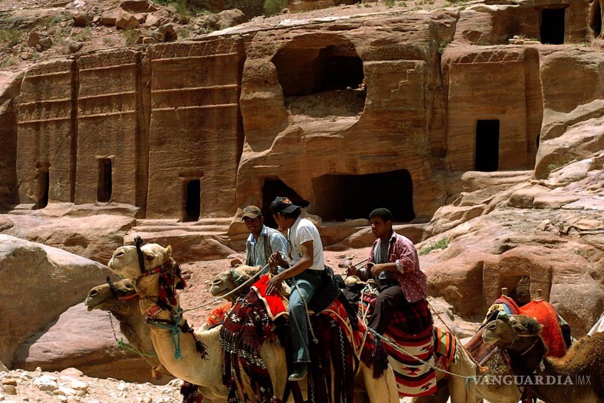 $!Grupo de beduinos en camello delante de algunas tumbas en el enclave arqueológico de Petra, en Jordania. EFE/Ballesteros/cg.