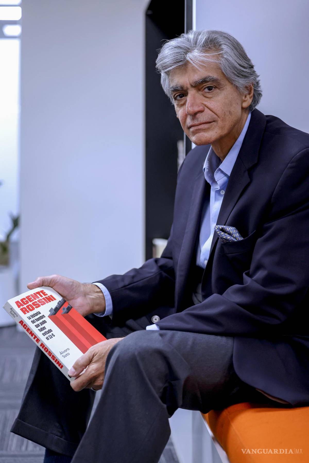$!El exagente del FBI Mark Rossini sostiene el libro ‘Agente Rossini. La historia del hombre que pudo haber evitado el 11-S”, del periodista Álvaro Soto.