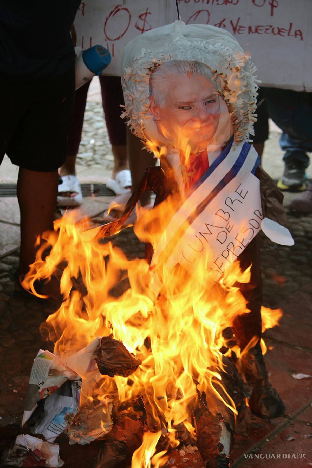 $!Migrantes encienden una piñata con una foto del presidente de Cuba, Miguel Díaz-Canel, a modo de protesta por la visita al país de varios presidentes a una cumbre convocada por Andrés Manuel López Obrador | Foto: EFE