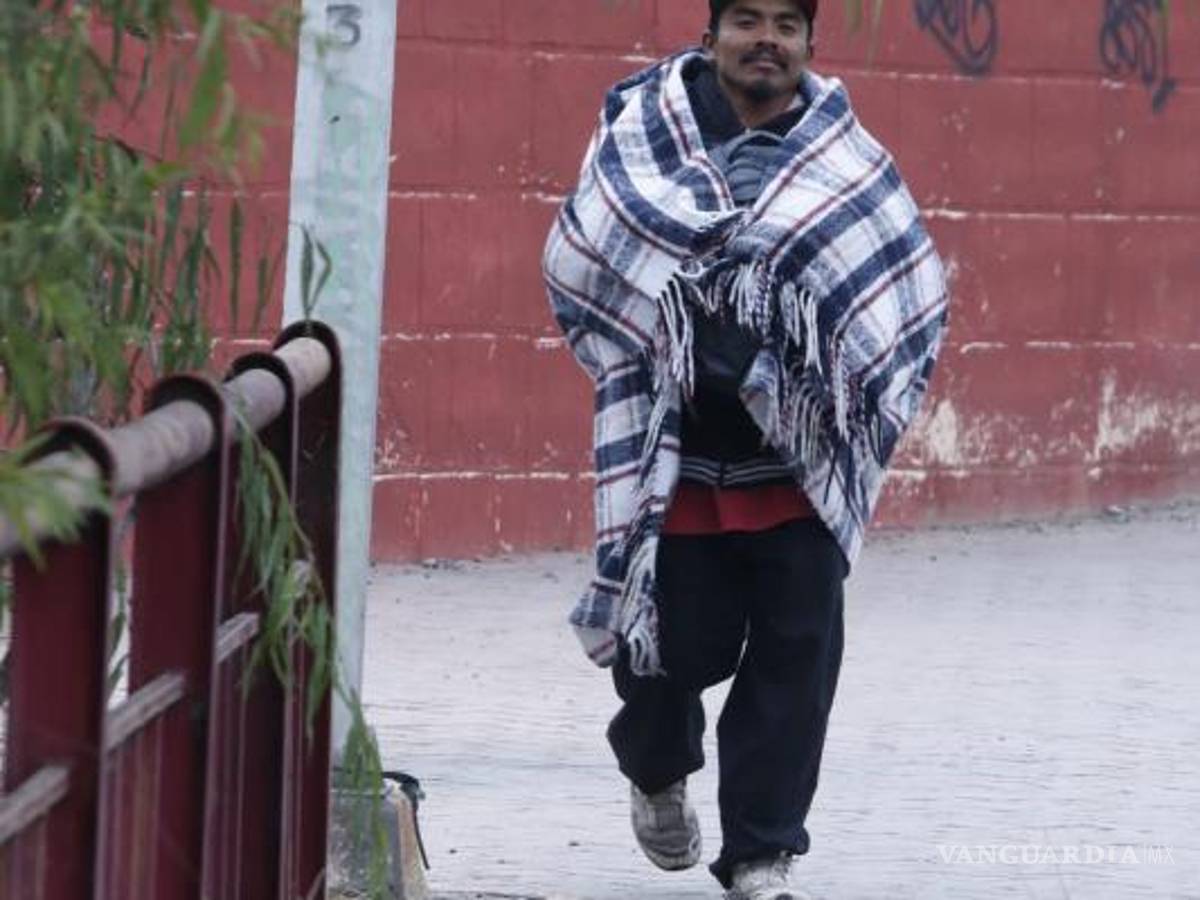 $!Humberto N camina hacia las vías del tren envuelto en una cobija. Para él el frío no es más que otra de las muchas condiciones en las que tiene que viajar.