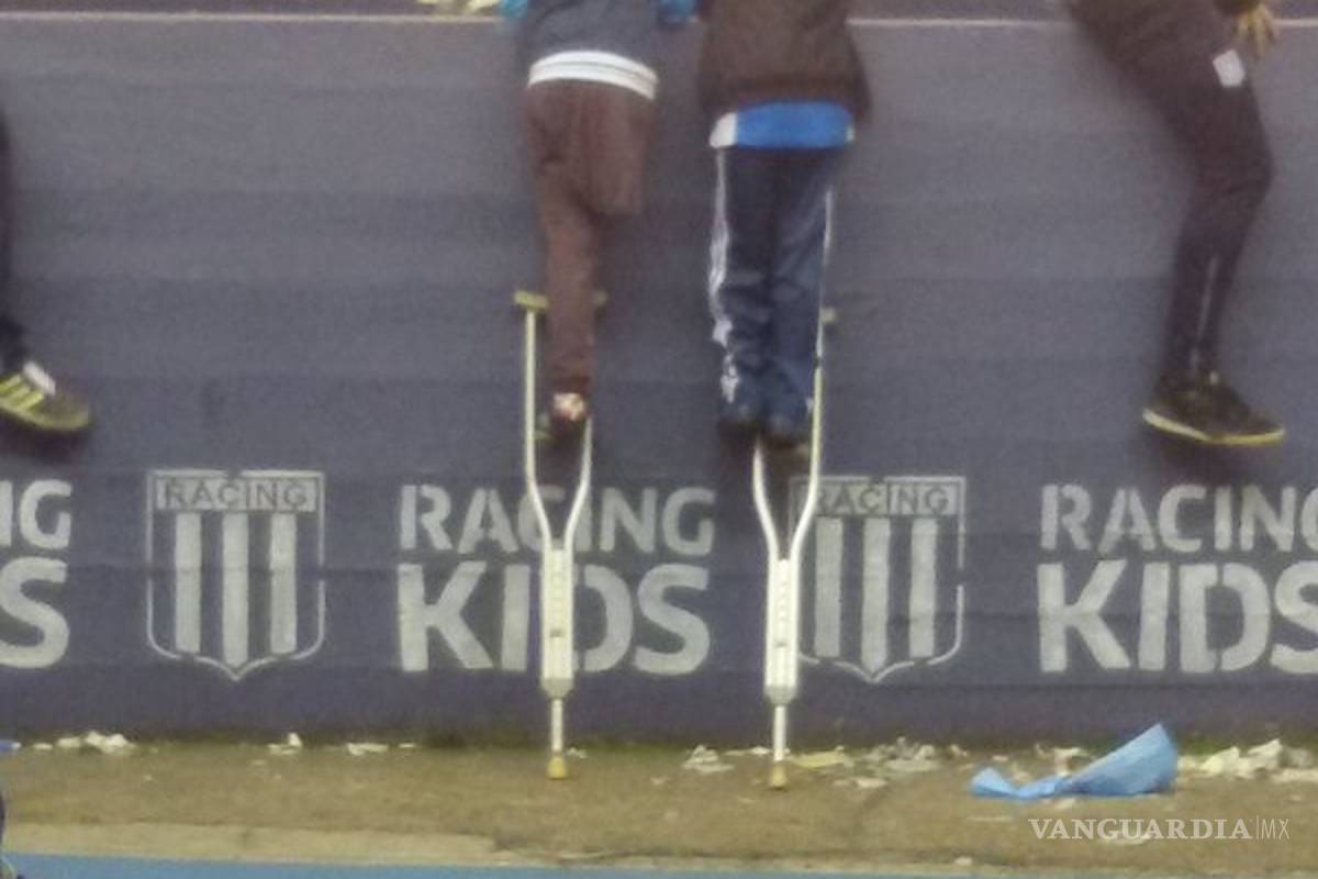 Niño presta muleta a su amigo para poder ver un partido de futbol
