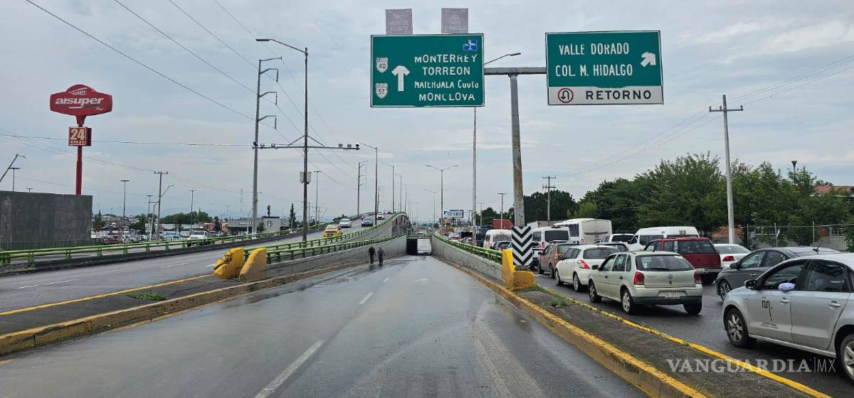 $!Largas filas de vehículos quedaron atrapados debido al estancamiento de agua en el paso a desnivel.