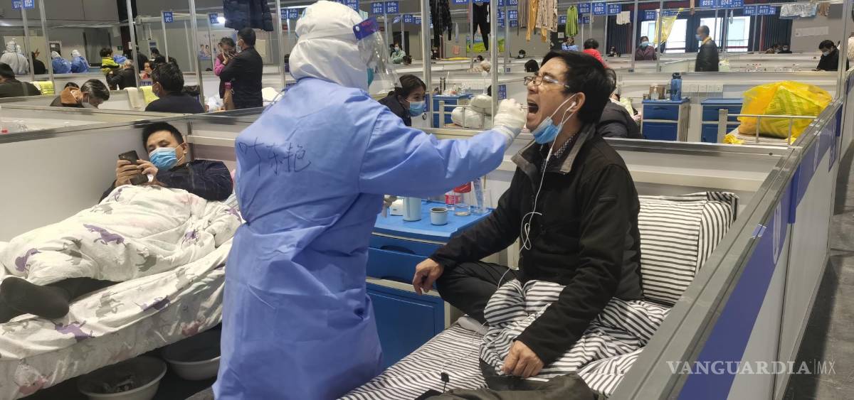 $!Una enfermera toman muestra de hisopos a un personas para la prueba de ácido nucleico en un hospital temporal para personas con COVID-19 en Shanghái, China.