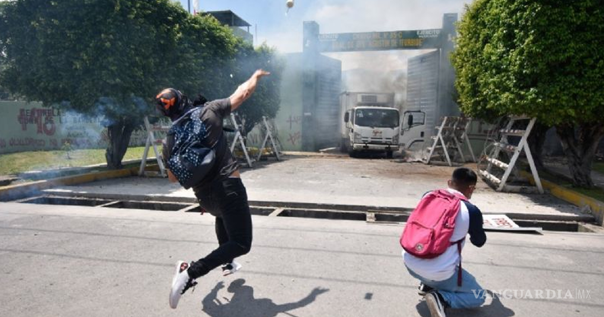 $!Siguen protestas de normalistas de Iguala, queman camión y destruyen fachada del 27 batallón