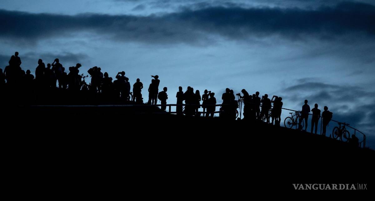 $!Un grupo de personas observa desde el Olympiaberg el atardecer y la aparición de la luna, en Múnich, Alemania, el 13 de julio de 2022.