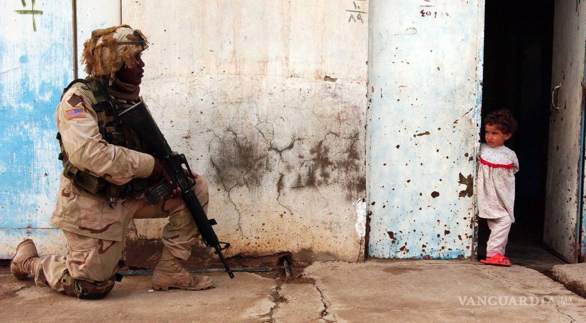 $!El soldado de primera clase Marcus Atkinson vigila una calle durante una patrulla en Tikrit, Irak, el 18 de diciembre de 2003.