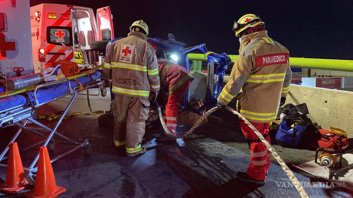 $!La conductora fue rescatada del interior del automóvil por elementos de la Cruz Roja, quienes utilizaron equipo hidráulico para liberarla tras la aparatosa volcadura registrada sobre el distribuidor vial El Sarape.