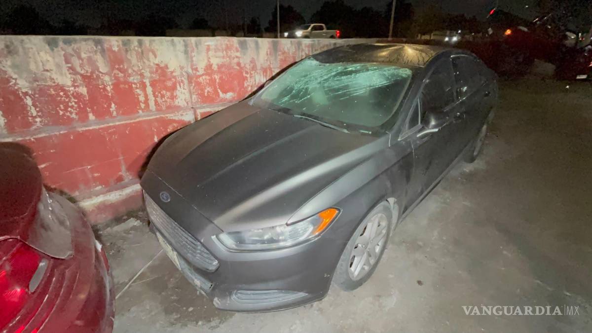 $!El Ford Fusion presentó daños en el parabrisas y parte del techo tras quedar parcialmente debajo de la camioneta.