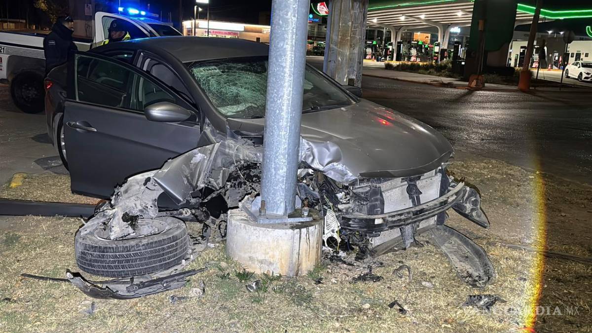 $!El vehículo Hyundai Sonata quedó completamente destruido tras impactarse contra la base de un semáforo y un poste metálico en la colonia Meza de Lourdes.