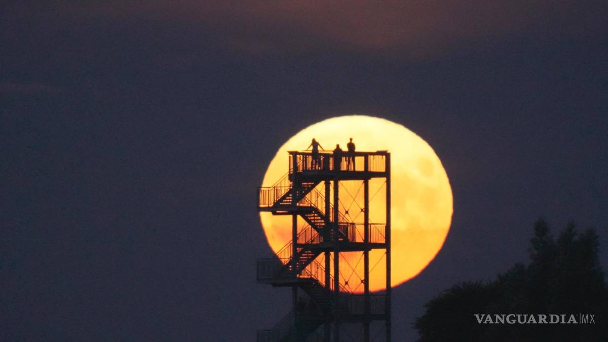 $!La gente ve salir la luna desde la torre de observación en Syke, Alemania, el miércoles 13 de julio de 2022.