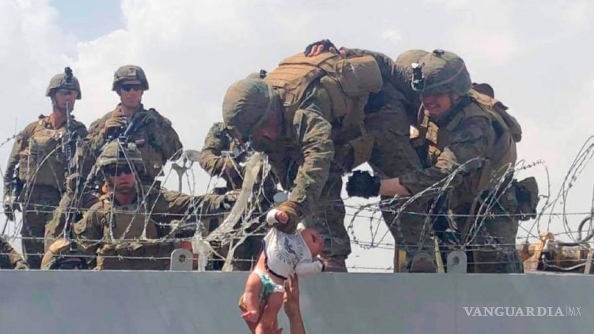 $!En esta imagen de Omar Haidari y tomada el jueves 19 de agosto de 2021, que muestra a soldados estadounidenses levantando a un bebé a través de una pared en el aeropuerto de Kabul en Afganistán.