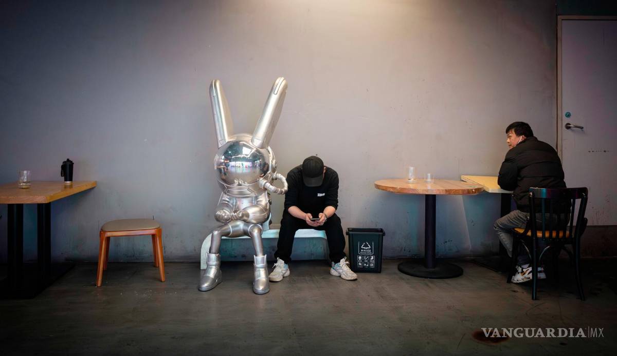 $!Los trabajadores hacen una pausa frente a un restaurante en Shanghái, China.