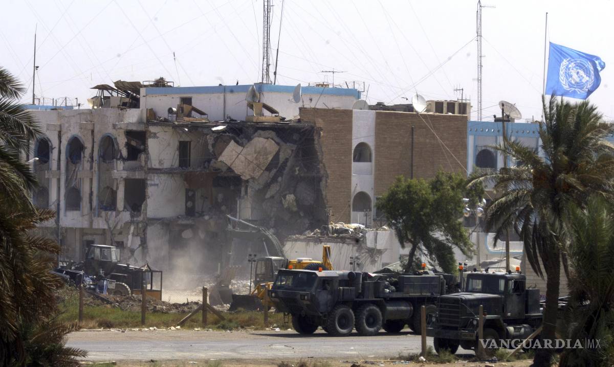 $!Vehículos militares estadounidenses pasan frente a la sección derrumbada de las oficinas de Naciones Unidas, el sábado 23 de agosto de 2003 en Bagdad, Irak.