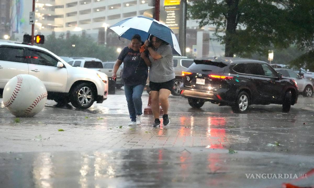 $!Los fanáticos se dirigen al Minute Maid Park mientras una fuerte tormenta golpea antes de un juego de béisbol entre los Atléticos de Oakland y los Astros de Houston.