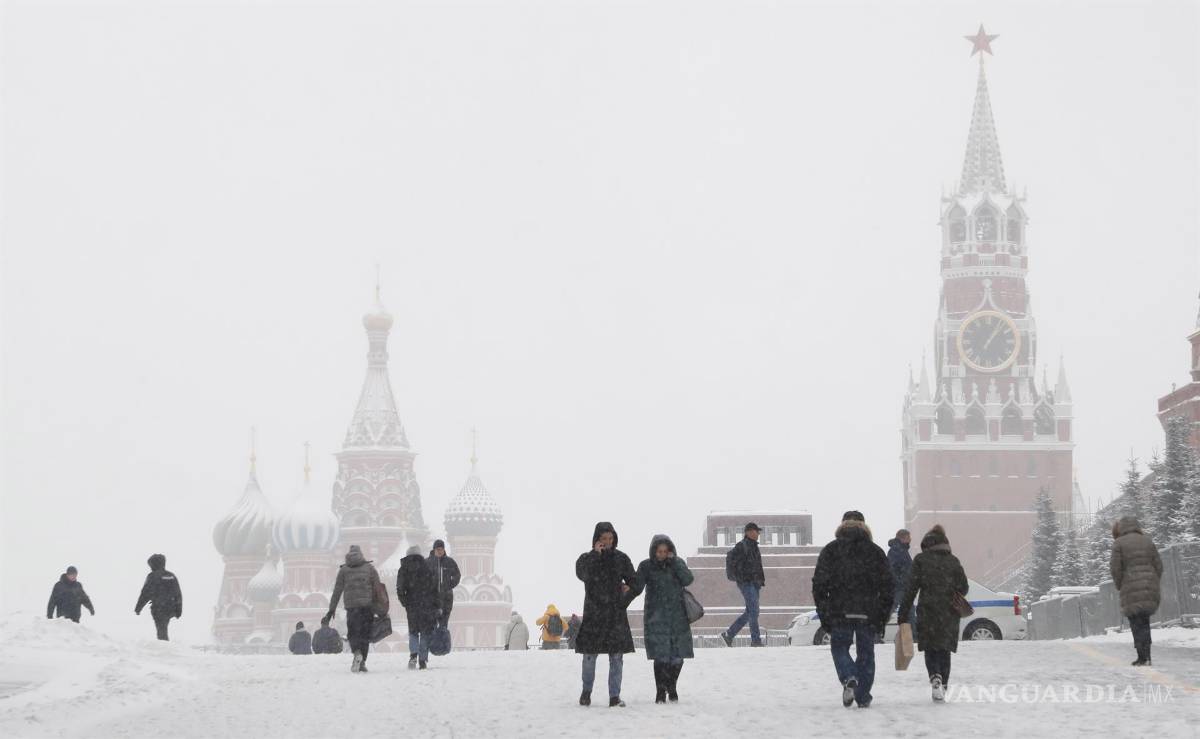 $!Las personas que llevaban máscaras protectoras contra el Covid-19 caminan por la Plaza Roja fuera del Kremlin durante una nevada en Moscú, Rusia. EFE/EPA/Maxim Shipenkov