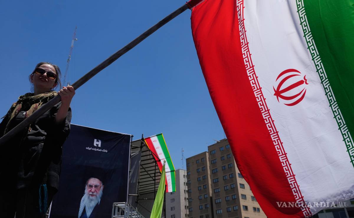 $!Una mujer ondea una bandera iraní durante una campaña a favor del gobierno en el centro de Teherán, Irán.
