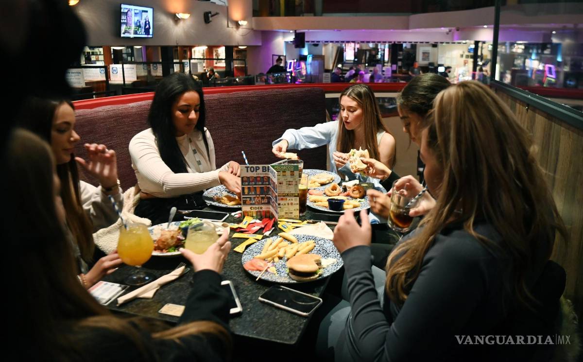 $!Un grupo de jóvenes comen en un restaurante de Londres. El alimento es el medio de civilización más ubicuo y siempre ha moldeado el mundo, pero no siempre para bien. EFE/EPA/Andy Rain