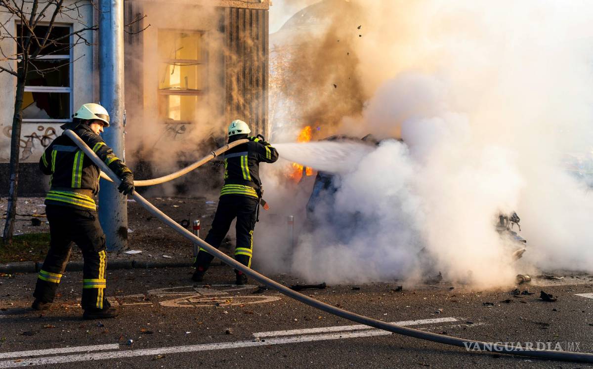 $!Los bomberos intentan extinguir un automóvil en llamas después de un ataque ruso en Kiev, Ucrania.
