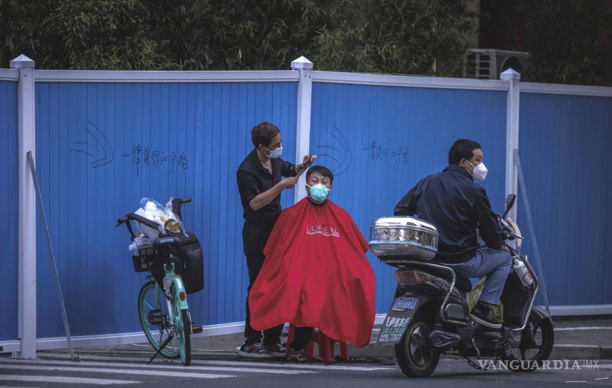 $!Un hombre se corta el pelo en la calle en medio del bloqueo de Covid-19 en curso en Shanghái, China.