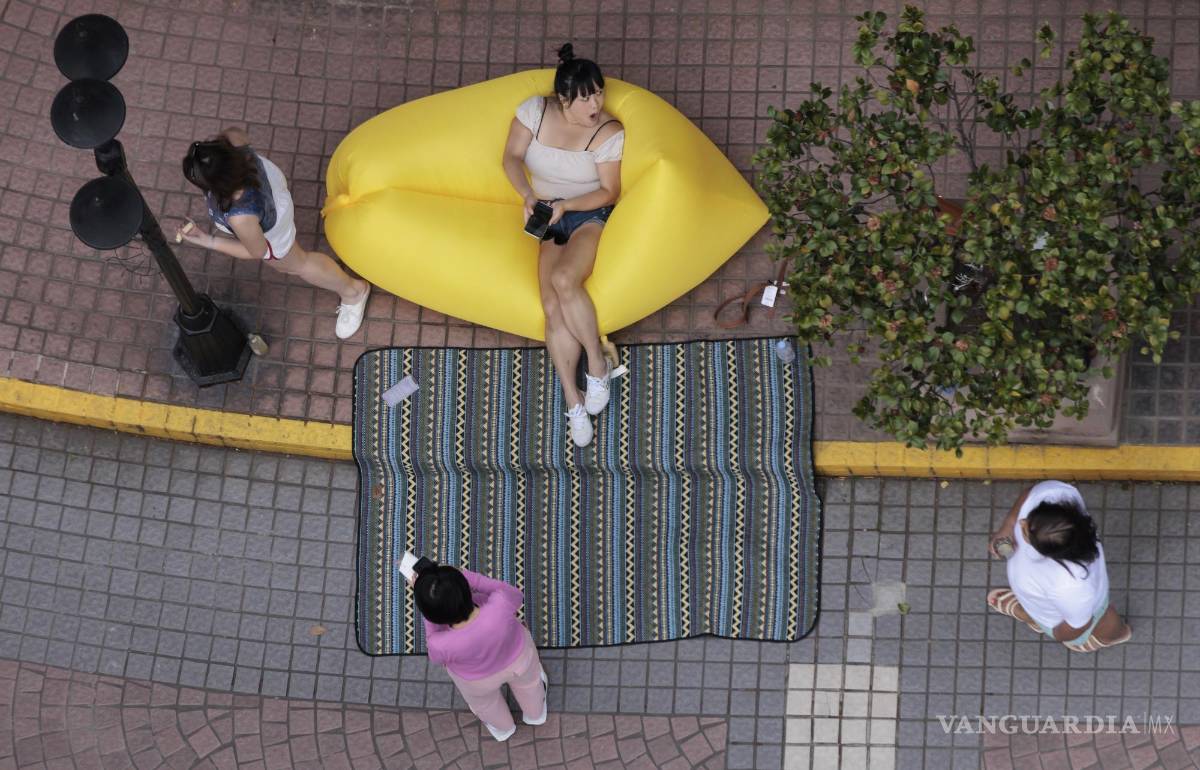 $!Las personas en cuarentena se reúnen fuera de su complejo residencial en Shanghái, China.