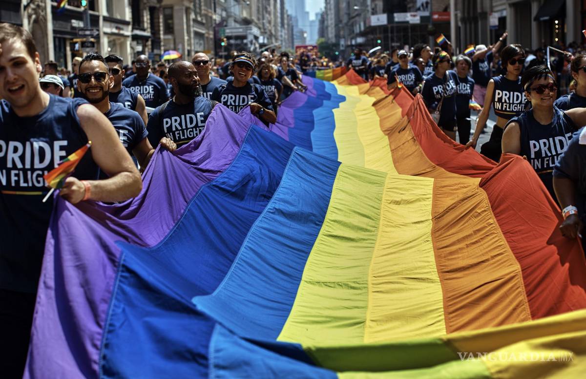 $!Unas personas con una bandera LGBTQ a lo largo de la Quinta Avenida durante el Desfile del Orgullo Gay de la ciudad de Nueva York.