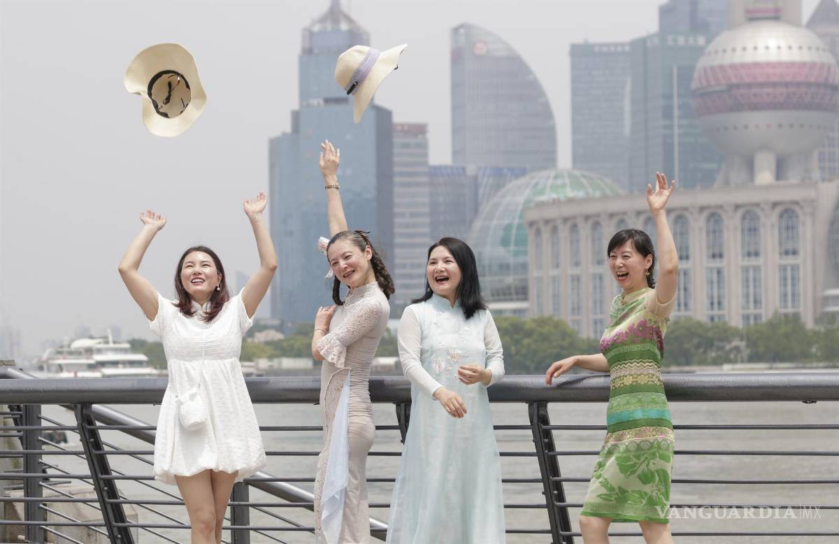 $!Las mujeres lanzan sus sombreros al aire para celebrar el alivio de las restricciones de COVID-19, en Shanghái, China.
