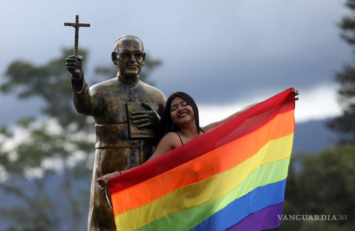 $!Una integrante de la comunidad LGBTI+ junto a una estatua de San Óscar Romero, durante la Marcha del Orgullo en San Salvador, El Salvador.
