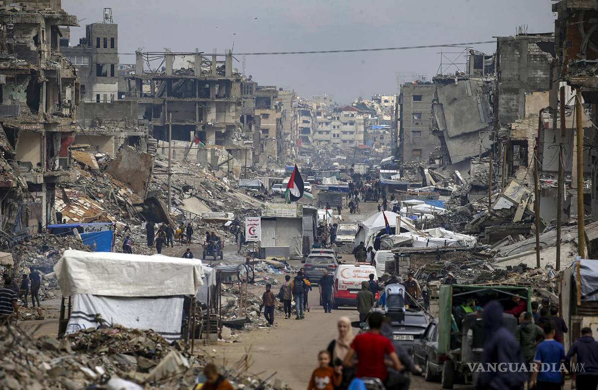 $!Palestinos caminan entre refugios improvisados y las ruinas de edificios residenciales destruidos a lo largo de la calle Al-Jalaa’, en la ciudad de Gaza.