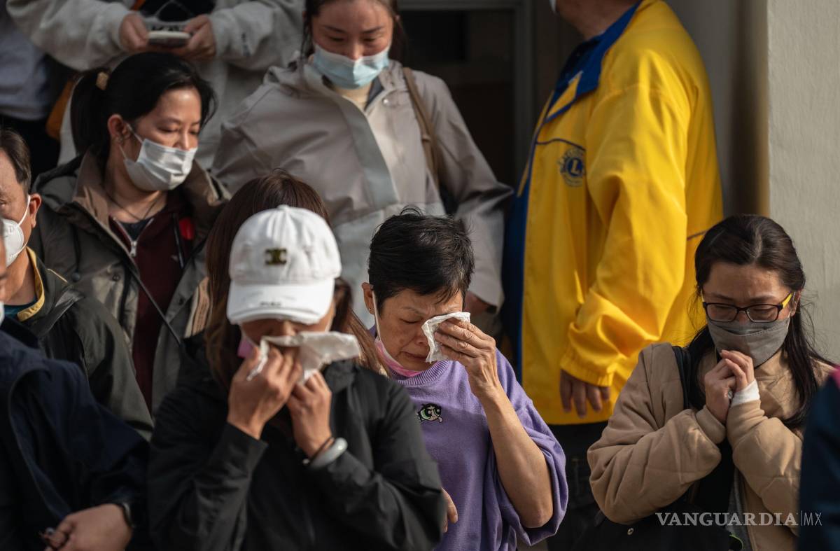 $!Personas con familiares desaparecidos reaccionan después de revisar fotografías de los fallecidos en Tai Po, Hong Kong.