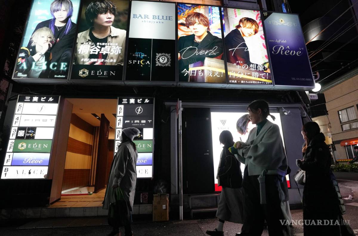 $!Las mujeres pasan junto a un cartel de un ‘Host Club’ en el distrito de Kabukicho, Shinjuku en Tokio, Japón.