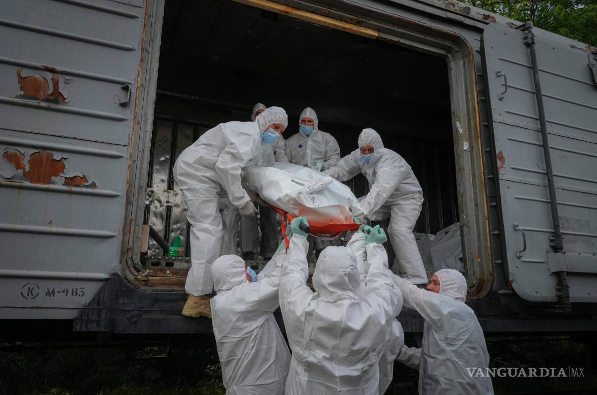 $!Soldados ucranianos cargan cuerpos de soldados rusos en un vagón frigorífico de ferrocarril en Kiev, Ucrania.