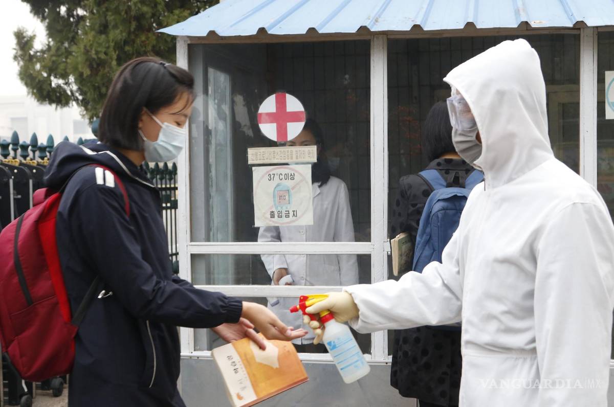$!Una estudiante con mascarilla se desinfecta las manos antes de ingresar a la Escuela Secundaria No. 2 de Kumsong en Pyongyang, Corea del Norte.