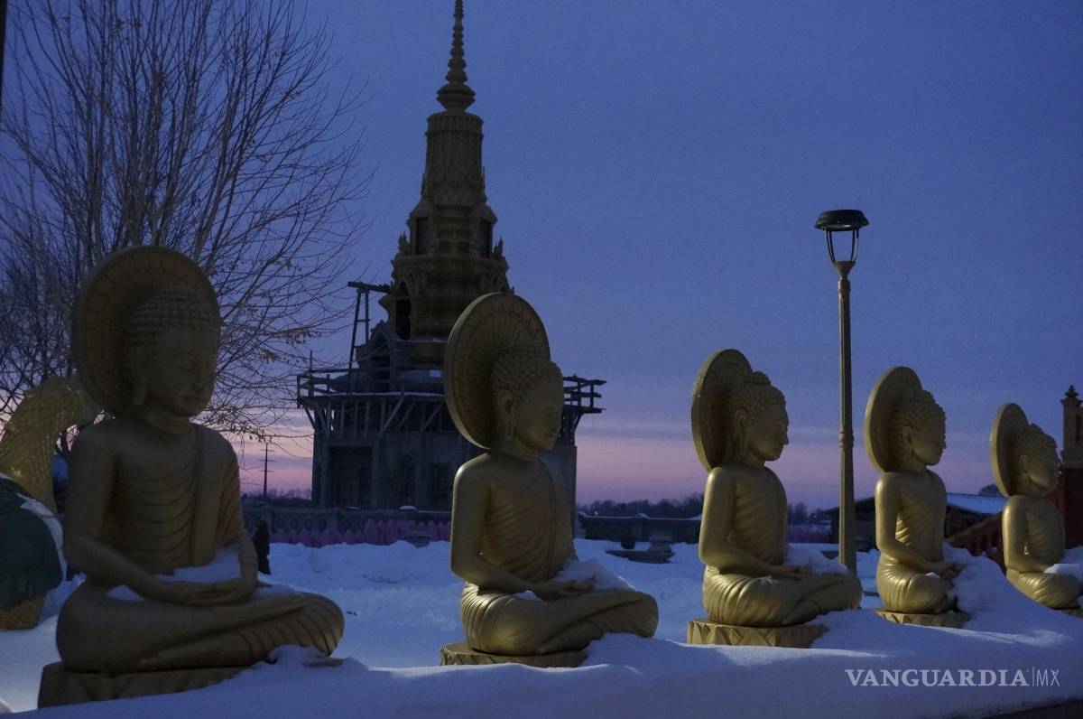 $!Estatuas de Buda y la estupa que alberga sus reliquias al anochecer en el complejo del templo Watt Munisotaram el sábado 4 de febrero de 2023 en Hampton, Minnesota.