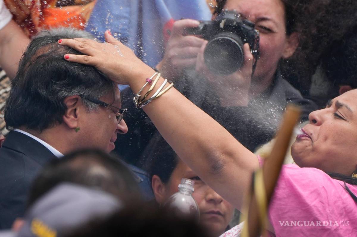 $!Una mujer indígena escupe agua sobre la cabeza del presidente electo Gustavo Petro, durante una ceremonia de toma de posesión “popular y espiritual”.