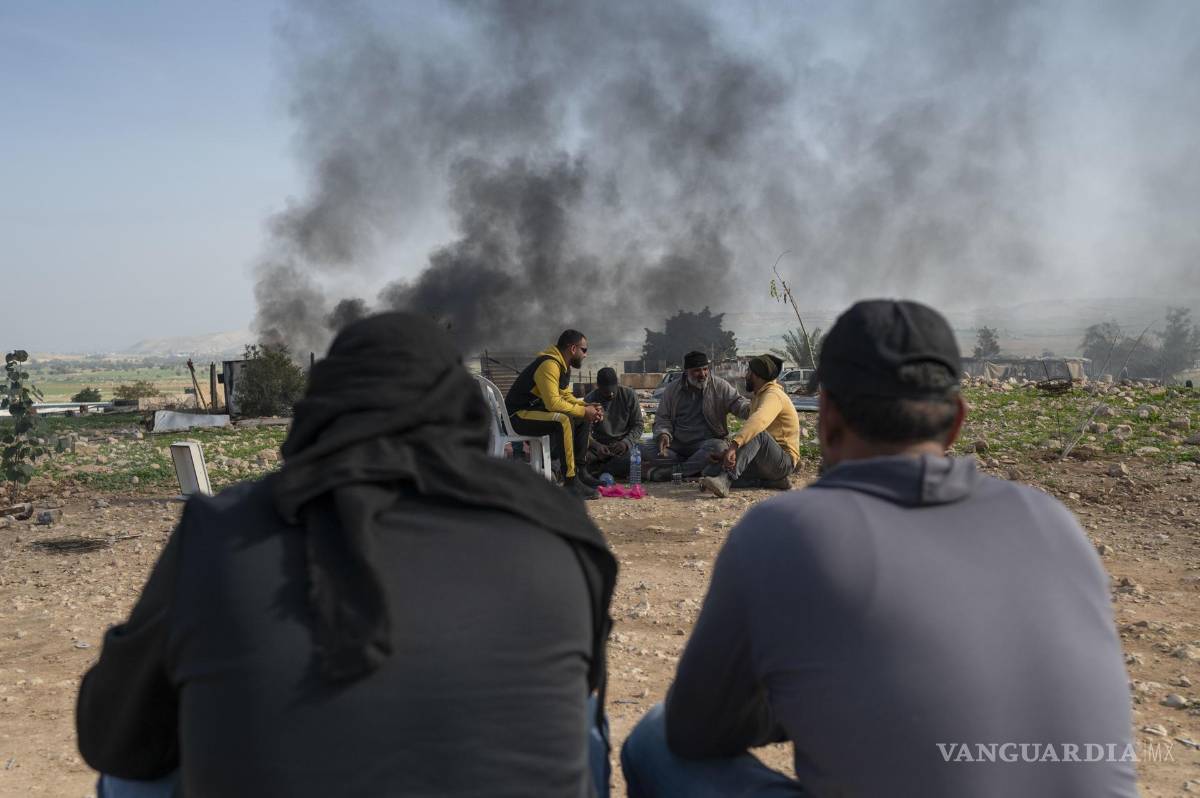 $!Un grupo de palestinos beduinos toman té mientras concluye el desalojo de sus vivienda en la localidad cisjordana de Ras Ein Al Auja.