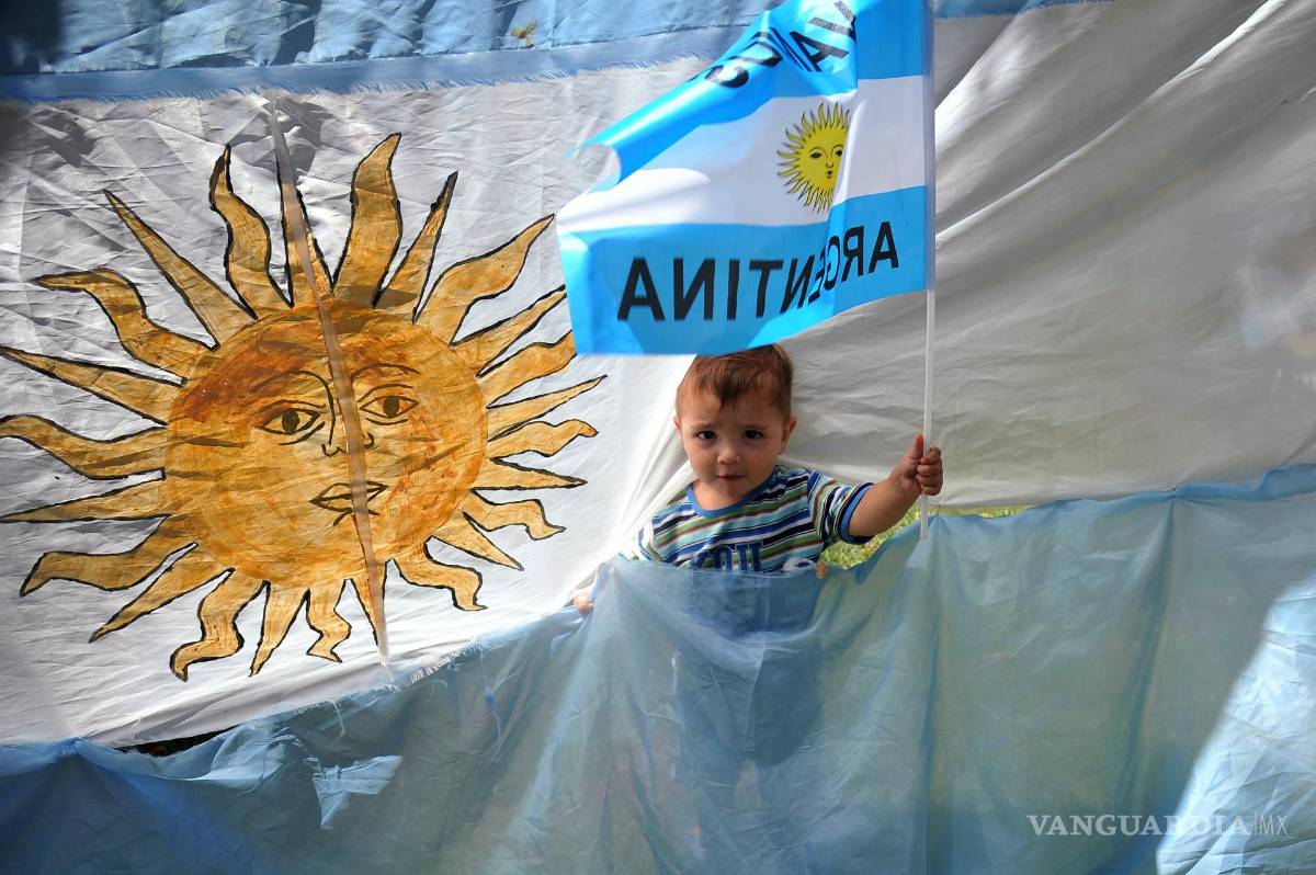 $!Un niño posa con banderas de Argentina durante la celebración de su triunfo de la selección argentina en el Mundial de Qatar 2022 en una calle de Buenos Aires.