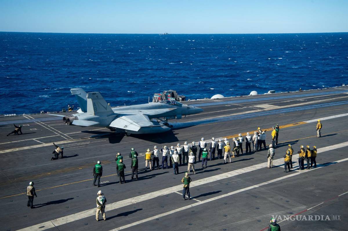 $!Miembros de la OTAN y miembros del servicio italiano observan nn F/A-18E Super Hornet en la cubierta de vuelo del Nimitz. EFE/EPA/MCSN JACK HOPPE/US NAVY