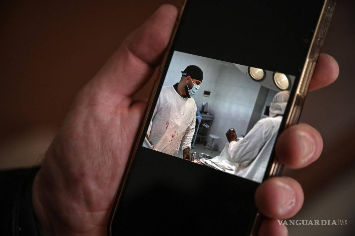 $!El Dr. Samer al-Sheikh muestra fotos en su teléfono de su trabajo quirúrgico en Ucrania, en su casa de Earl’s Court, Londres.
